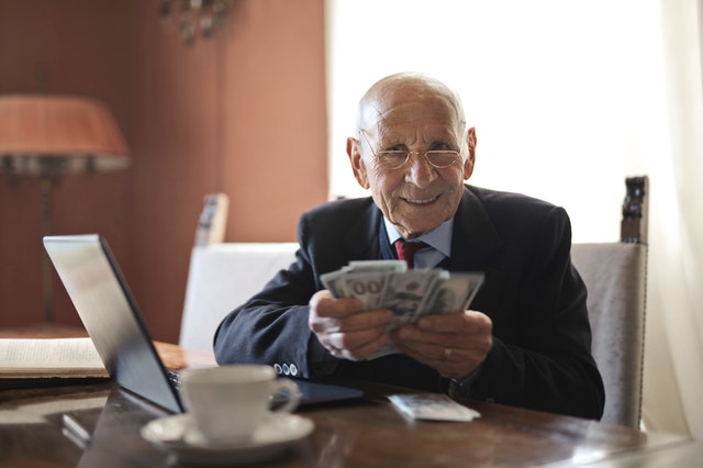 Persona mayor con billetes en las manos simulando Modelo Contrato Donación de Dinero